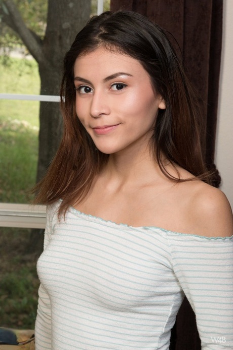 Young brunette Amelia Pearl holds her face firm while petting her bald pussy