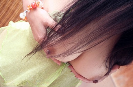 Beautiful Thai girl Oki Koew uncovers her nice tits and bush on a balcony