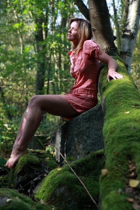 Young girl and her boyfriend have sex on moss covered boulders in a forest