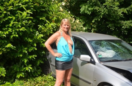 Older blonde Sweet Susi sucks a dick by a wrecked automobile in the backyard