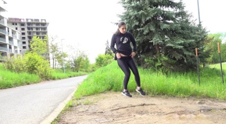 Clothed girl Lara Fox pulls down black leggings to pee by the side of a road