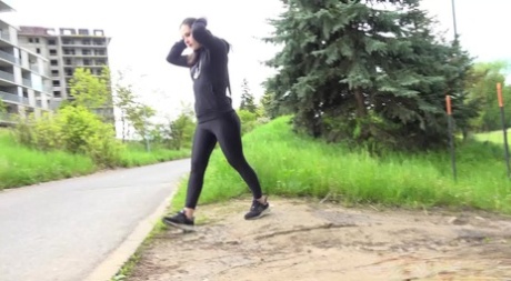 Clothed girl Lara Fox pulls down black leggings to pee by the side of a road