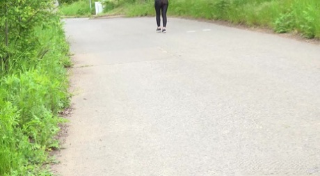 Clothed girl Lara Fox pulls down black leggings to pee by the side of a road