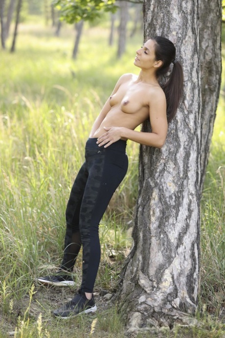 Cute teen Angela Allison unveils her small titties and masturbates in nature