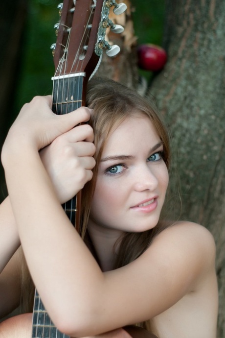 Absolutely gorgeous teen Bridgit A poses naked with a guitar outdoors