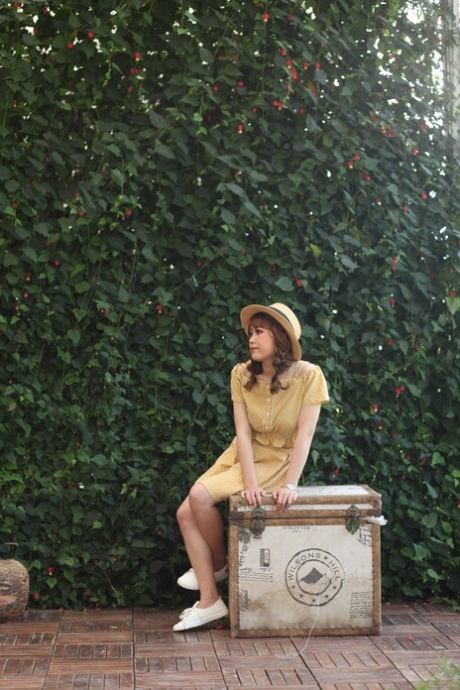 Lovely Asian model posing in her summer dress and white shoes in public