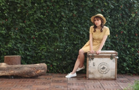 Lovely Asian model posing in her summer dress and white shoes in public