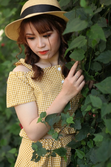 Lovely Asian model posing in her summer dress and white shoes in public