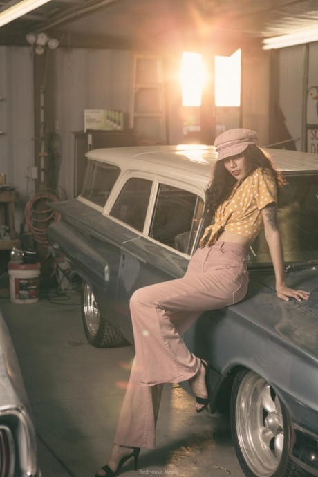 Glamorous brunette model posing in her garage in her hot outfit