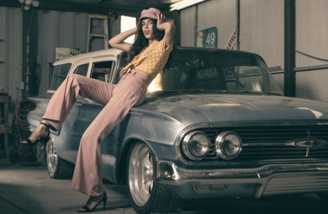 Glamorous brunette model posing in her garage in her hot outfit