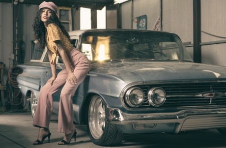 Glamorous brunette model posing in her garage in her hot outfit