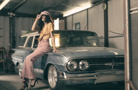 Glamorous brunette model posing in her garage in her hot outfit