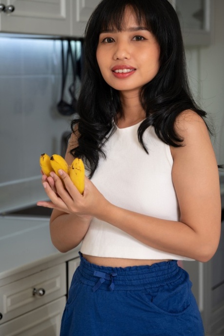 Glamorous Asian babe Norah shows her inviting shaved pussy up close